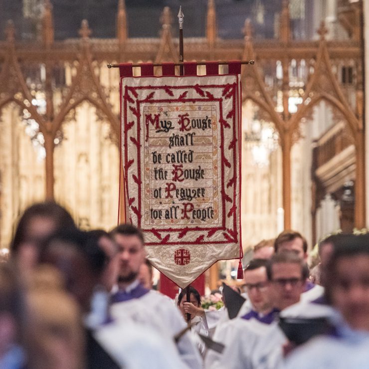 Choir processing and carrying a banner that reads, "My House shall be called the House of Prayer for all People," in the Nave of Washington National Cathedral