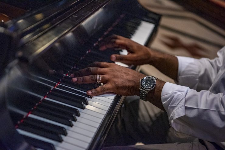 Detail of pianist hands playing over a piano keyboard