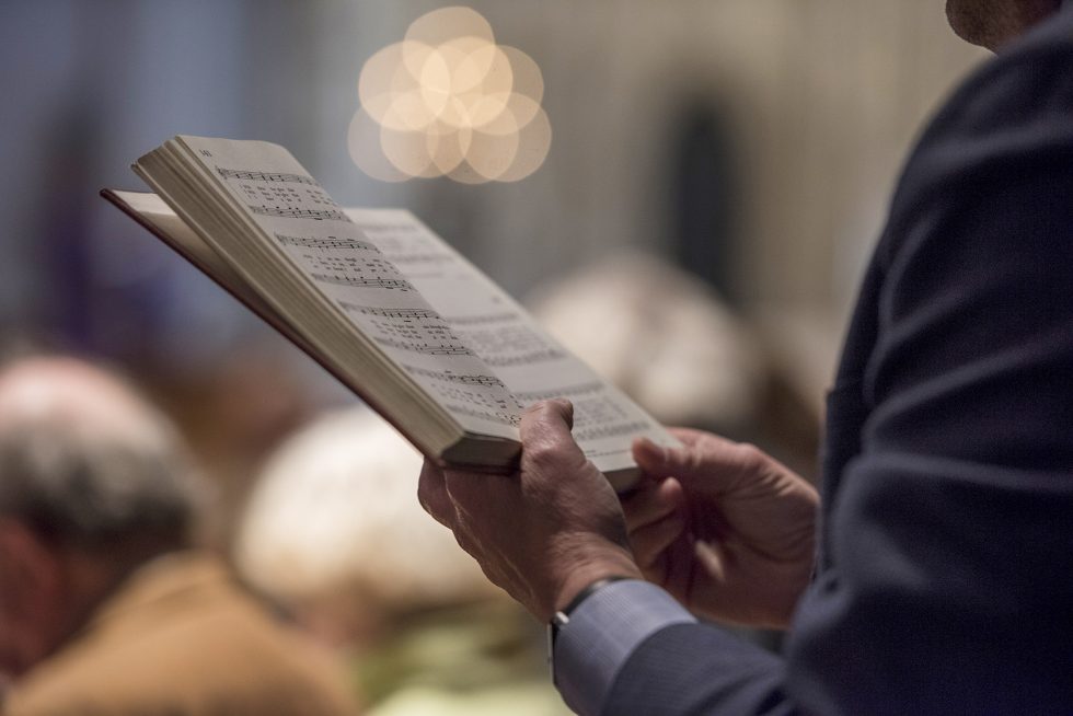 Worshipper holding Hymnal and singing