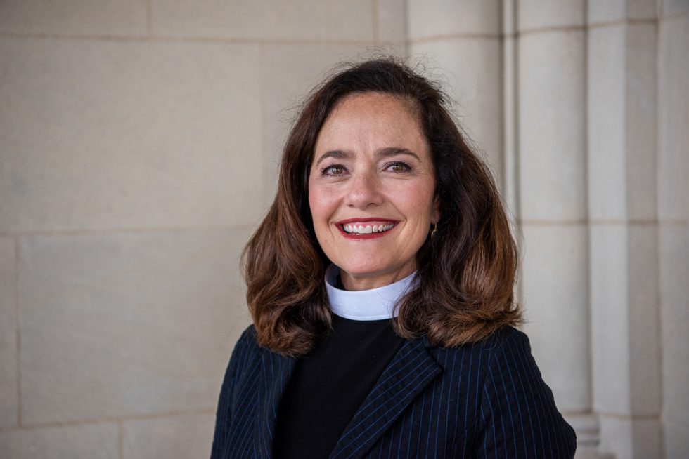 Headshot of Cathedral Vicar, smiling and wearing a pinstriped jacket over priestly vestment