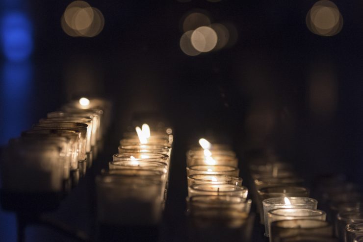 Lit votive candles in dimly lit interior of the Cathedral
