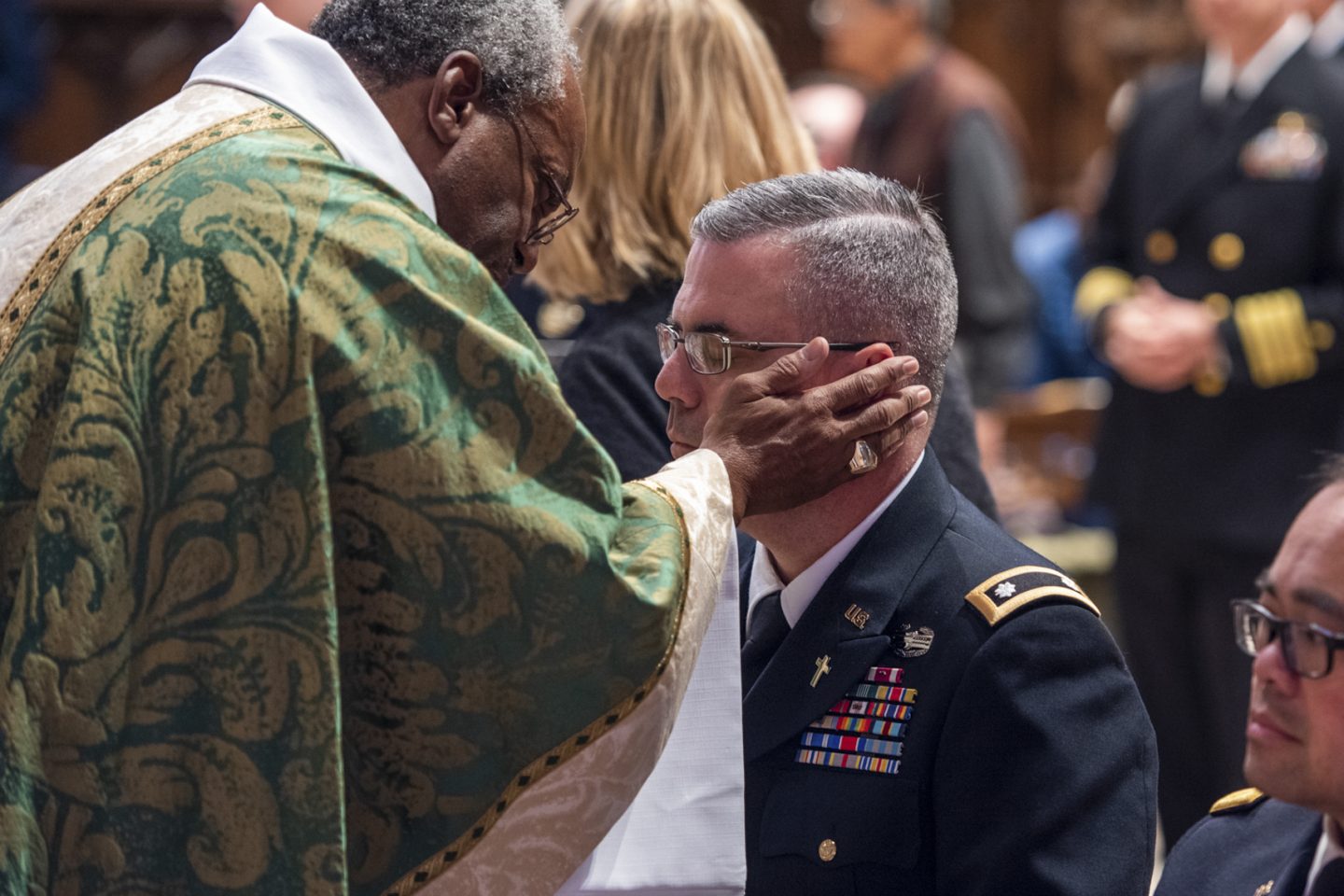 Bishop and military with other worshippers in the background during service
