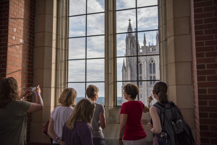 Visitors pointing and taking pictures at a window during a sightseeing tour
