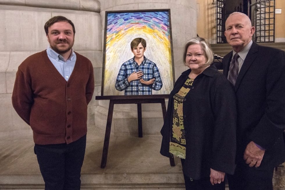 People standing around portrait of Matthew Shephard at Vigil in the Cathedral