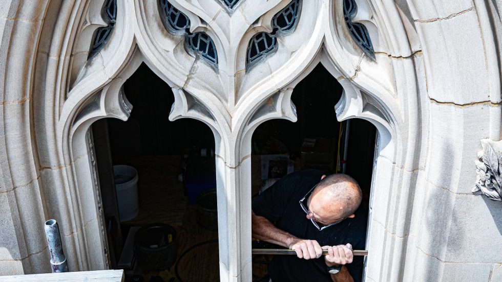 A man installs a stained glass window