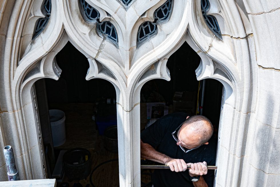 A man installs a stained glass window