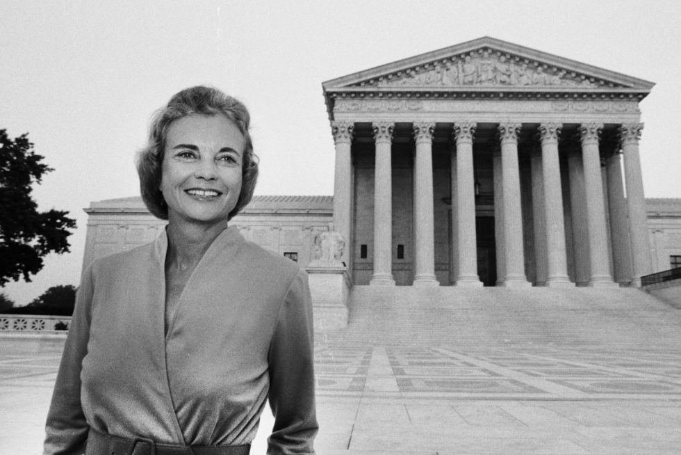 Former Justice Sandra Day O’Connor smiles in front of the United States Supreme Court. Photo credit: David Hume Kennerly.