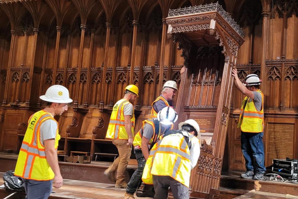 workers remove pews in a Cathedral