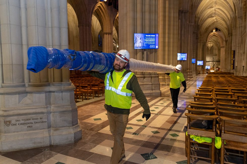 workers carry large organ pipes