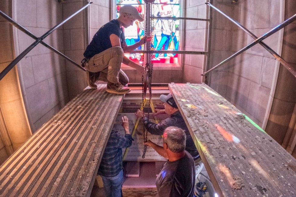 work crews install a stone tablet