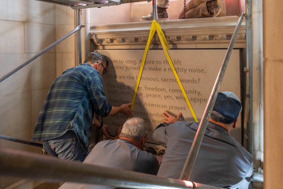 construction crews install a stone tablet