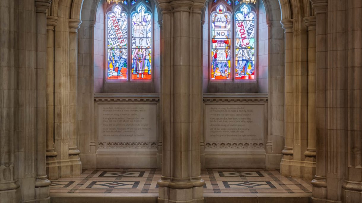 Frontal view of four lancets of stained-glass windows in a neo-Gothic Cathedral bay