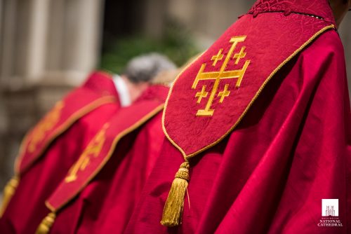 Close-up of clergy wearing red vestments and bowing
