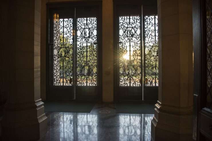 Bronze doors of the Cathedral's west facade from inside, with golden sunlight filtering in