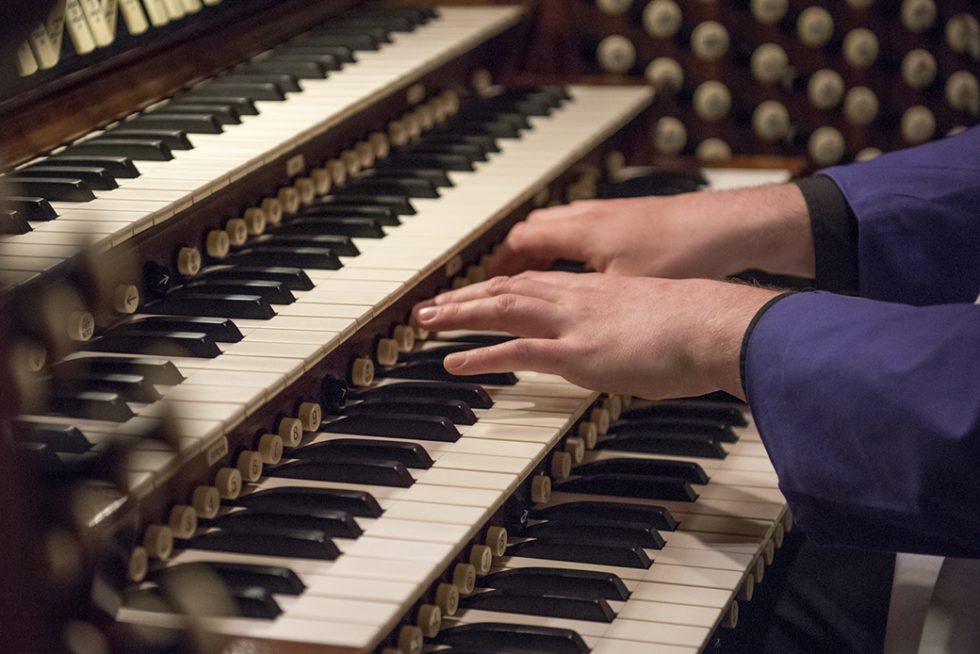 Close-up of organist hands on keyboard playing the organ