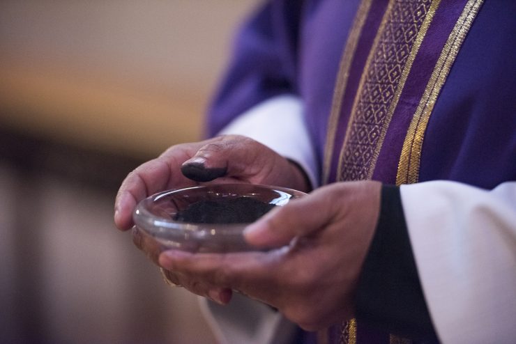 Close-up of clergy holding ash holder at beginning of Lent